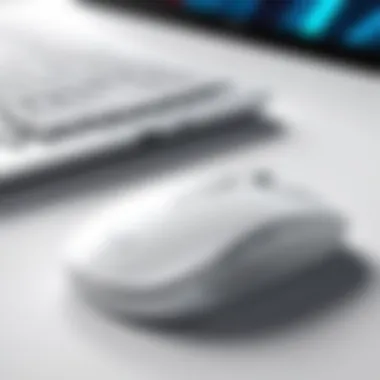 White wireless mouse next to a laptop